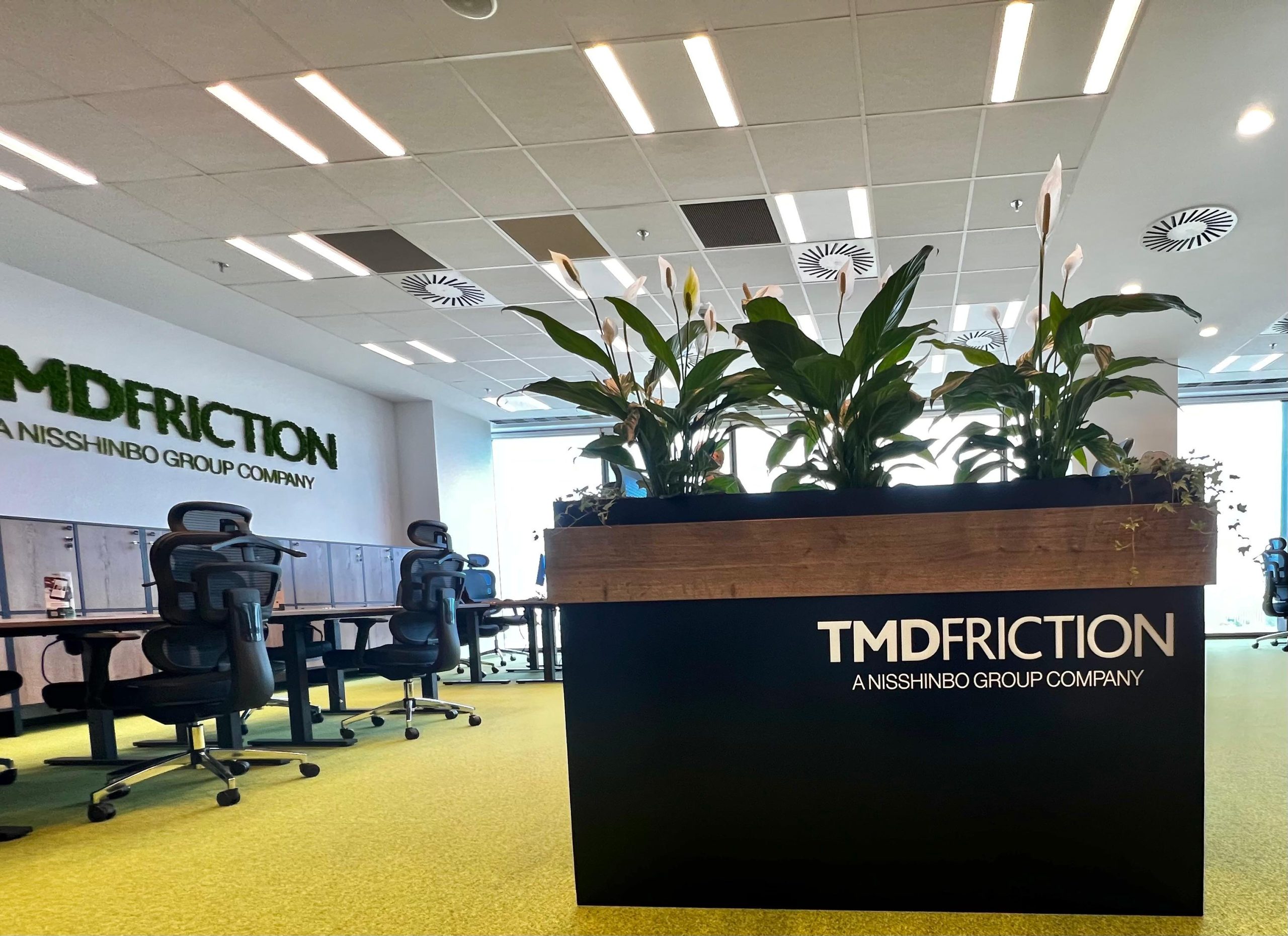 Jardiniere interior TMD Friction — detaliu logo volumetric și vegetație naturală birou